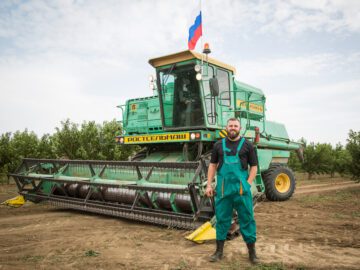 Крымский фермер работает с флагом России на комбайне